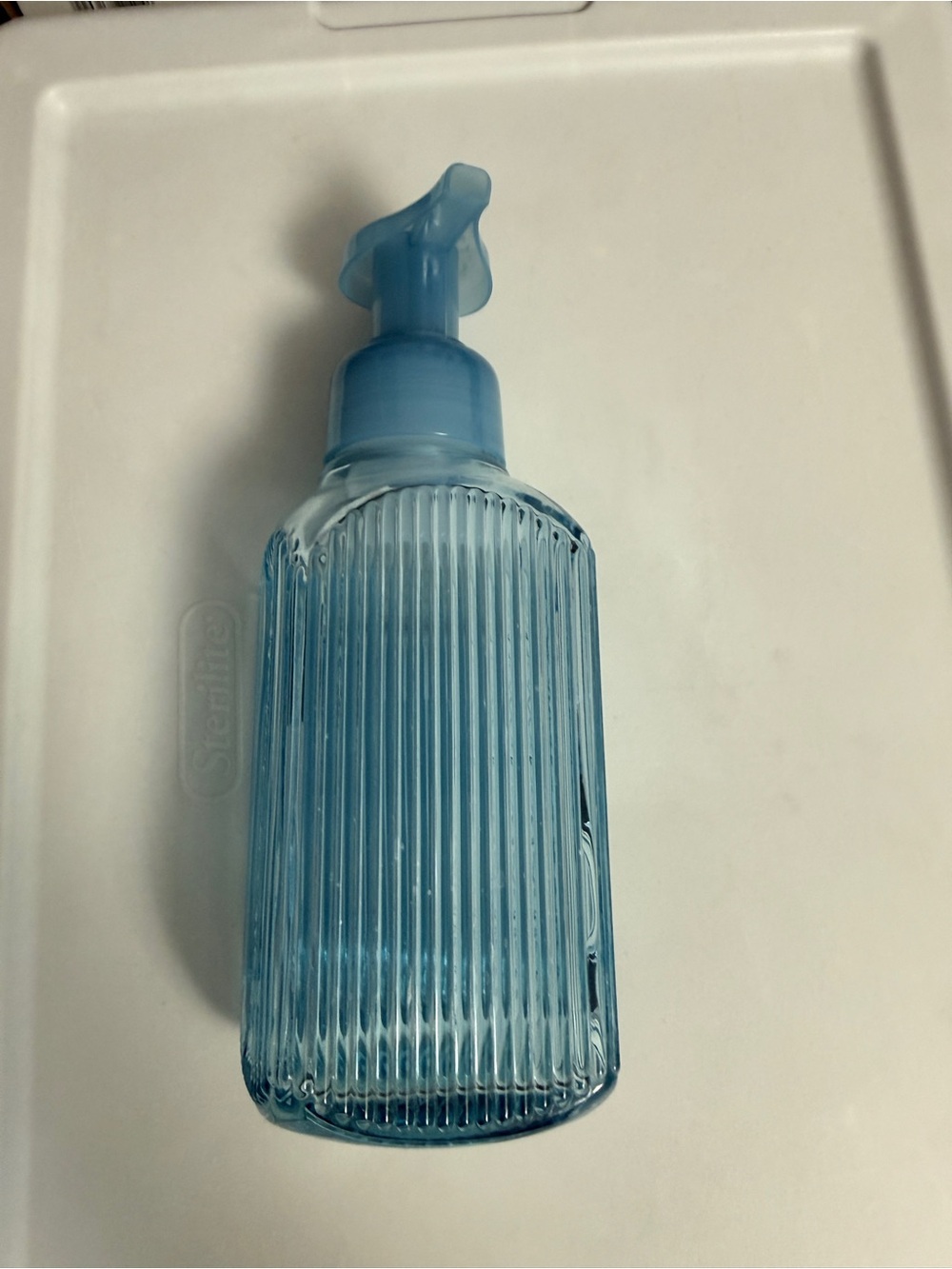 Bath and Body Works light blue ribbed glass foaming soap dispenser.